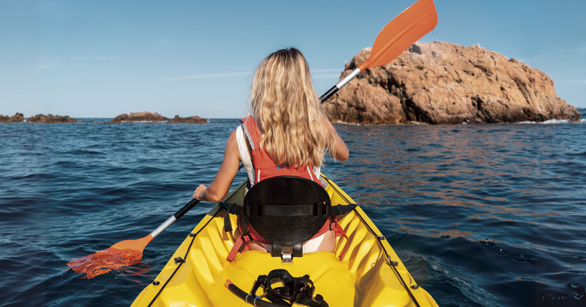 mujer practicando kayak en ibiza