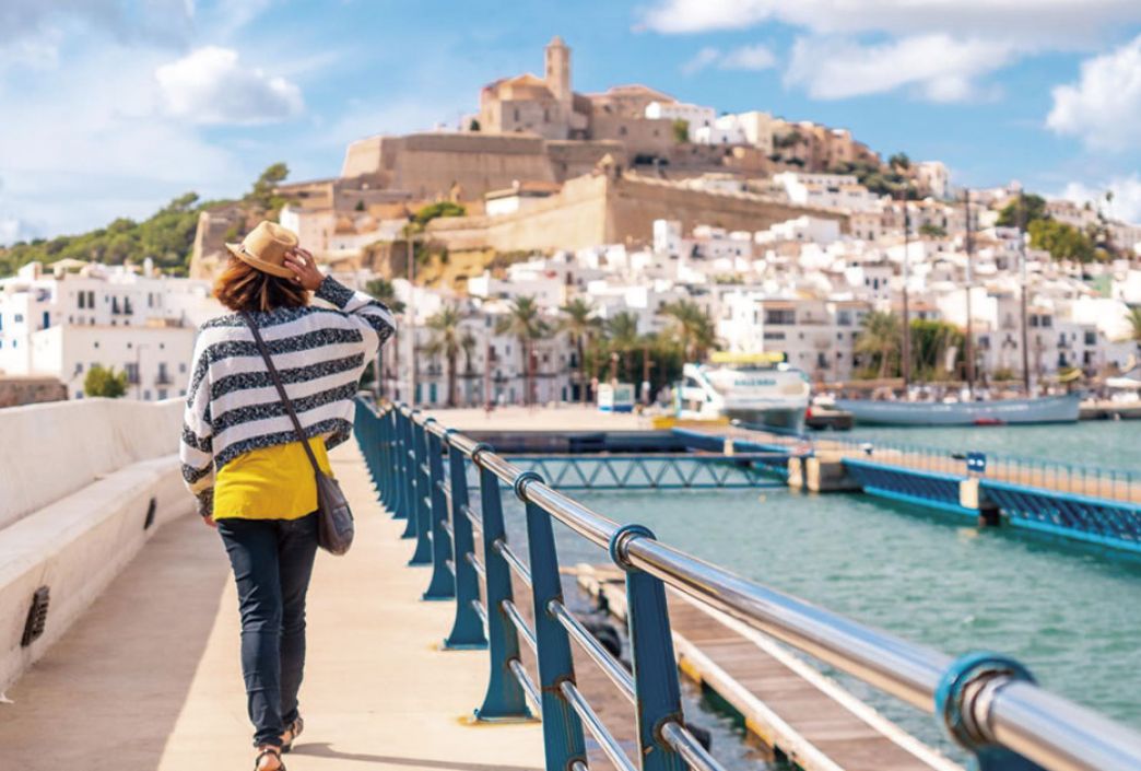 Mujer paseando por Dalt Vila con Ibiza de fondo