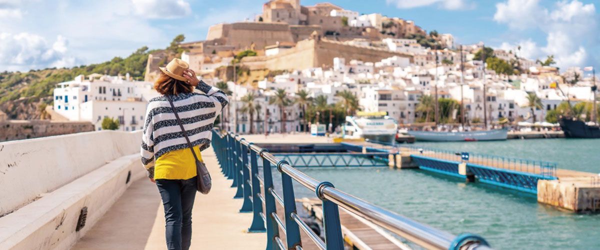 Mujer paseando por Dalt Vila con Ibiza de fondo