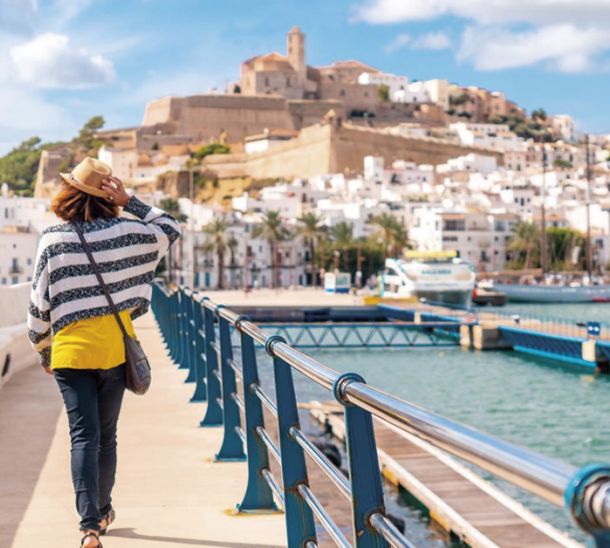 Mujer paseando por Dalt Vila con Ibiza de fondo